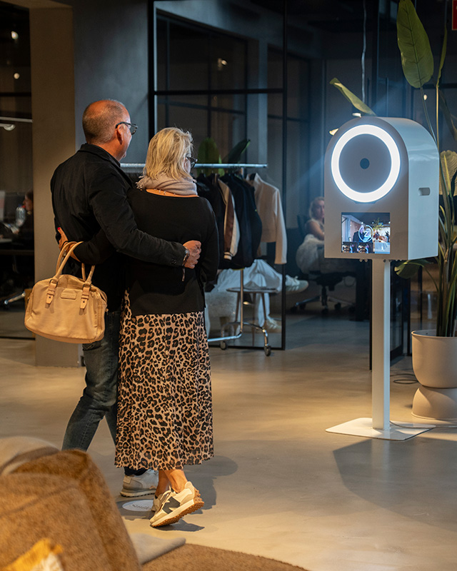 Een man en vrouw voor de photobooth tijdens event.